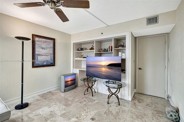 office with a textured ceiling, ceiling fan, and built in shelves