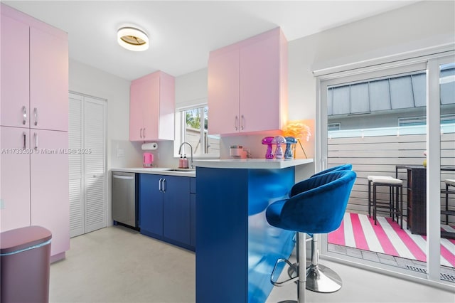 kitchen featuring dishwasher, sink, a breakfast bar area, kitchen peninsula, and blue cabinetry