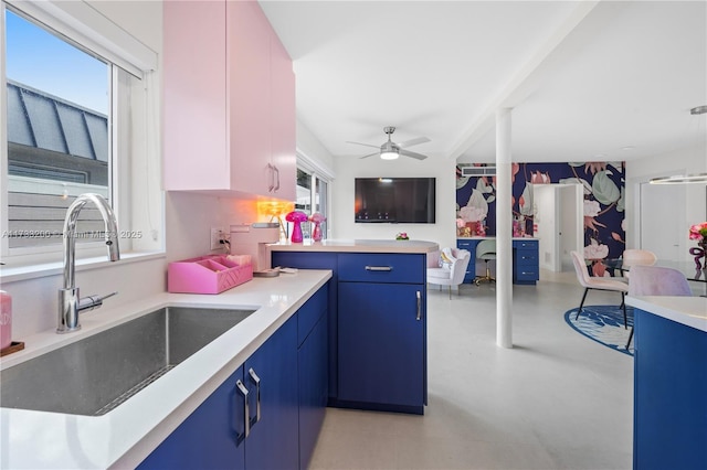 kitchen featuring ceiling fan, blue cabinets, kitchen peninsula, and sink