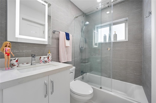 full bathroom featuring vanity, backsplash, enclosed tub / shower combo, and toilet