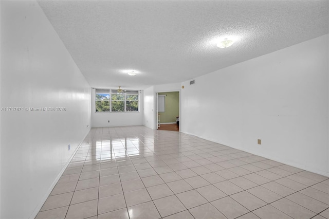 tiled spare room with a textured ceiling