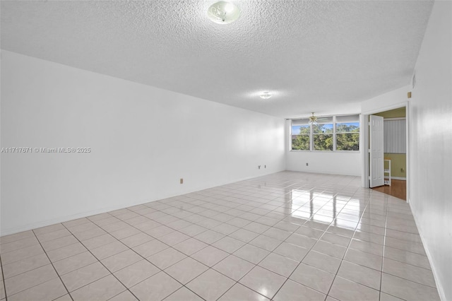 unfurnished room with light tile patterned flooring, ceiling fan, and a textured ceiling