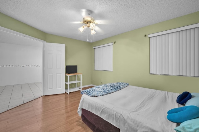 tiled bedroom featuring ceiling fan and a textured ceiling