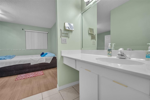 bathroom with tile patterned floors, a textured ceiling, and vanity