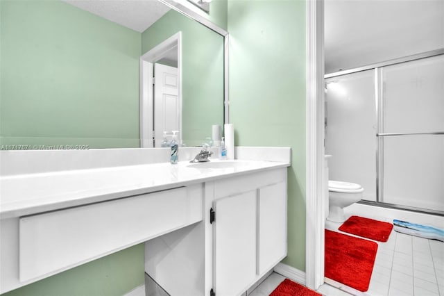 bathroom featuring vanity, a textured ceiling, a shower with door, and toilet