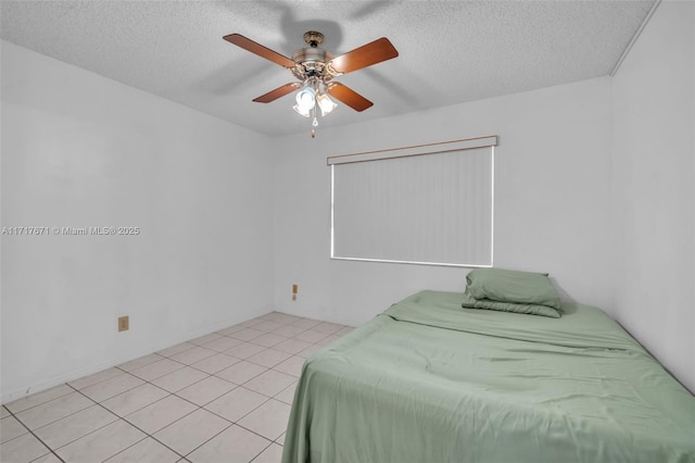 bedroom with ceiling fan, a textured ceiling, and light tile patterned floors