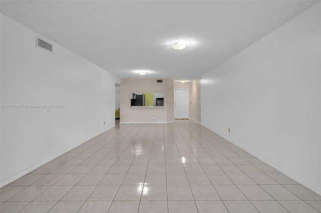 unfurnished living room featuring light tile patterned floors and a textured ceiling