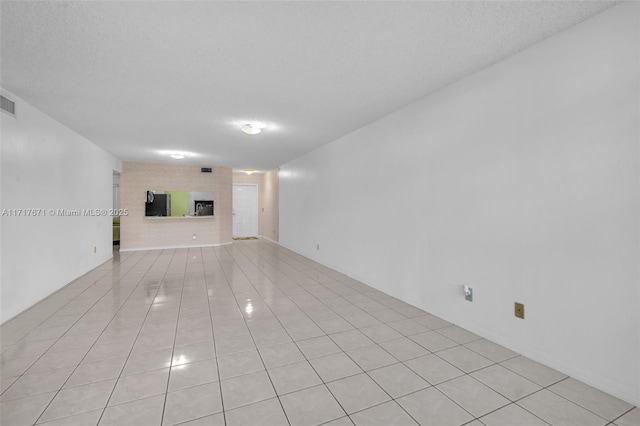 unfurnished living room featuring light tile patterned floors, a fireplace, and a textured ceiling