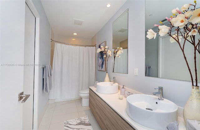 bathroom with tile patterned flooring, walk in shower, vanity, and toilet