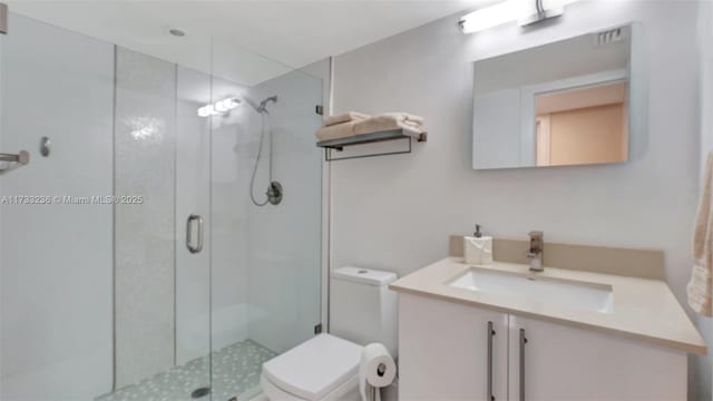 bathroom with vanity, an enclosed shower, and toilet