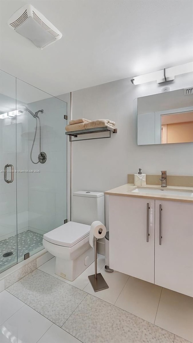 bathroom featuring vanity, tile patterned flooring, toilet, and walk in shower