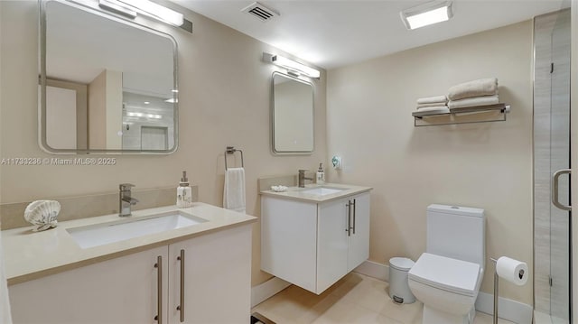 bathroom with tile patterned flooring, an enclosed shower, vanity, and toilet