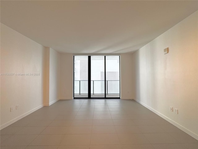 tiled spare room featuring floor to ceiling windows