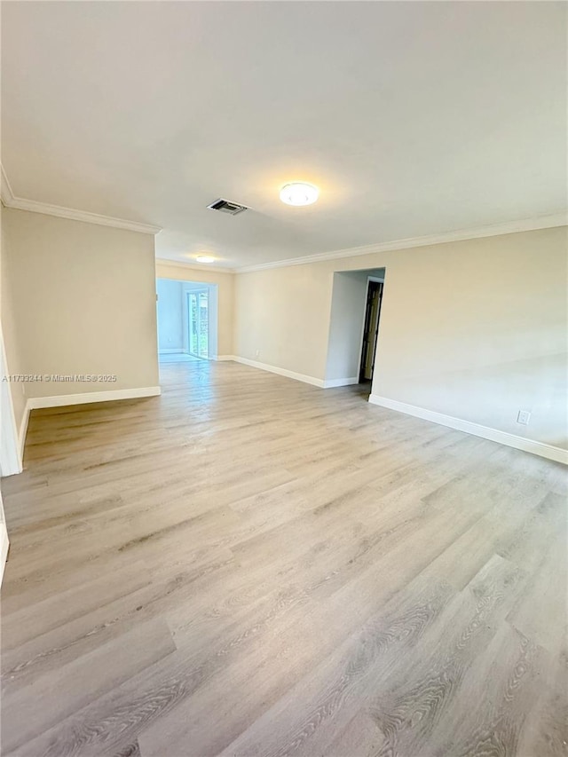 unfurnished room featuring ornamental molding and light hardwood / wood-style floors