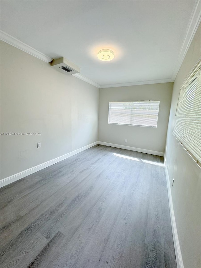 empty room with ornamental molding and wood-type flooring