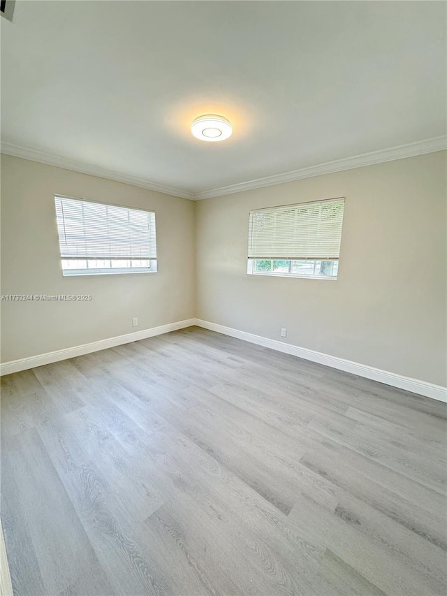 unfurnished room featuring ornamental molding and light hardwood / wood-style floors