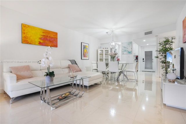 tiled living room featuring an inviting chandelier