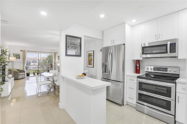 kitchen featuring white cabinetry, light tile patterned floors, backsplash, and appliances with stainless steel finishes