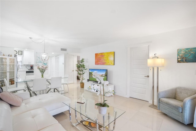 tiled living room featuring a notable chandelier