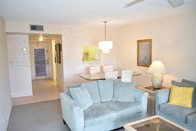 living room featuring a chandelier, a textured ceiling, and light tile patterned floors