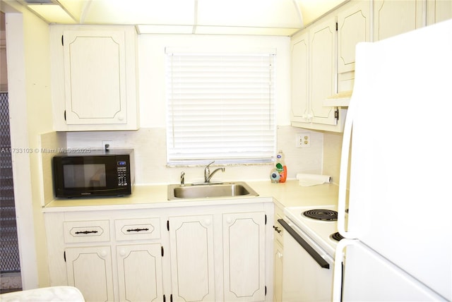 kitchen with white appliances, sink, and white cabinets