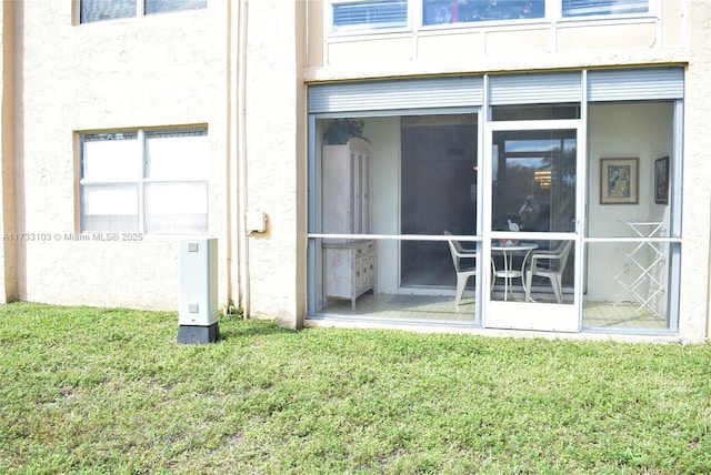 rear view of house with a sunroom and a yard