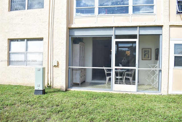 exterior space featuring a sunroom and a lawn