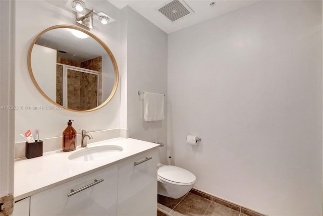 bathroom featuring vanity, a shower with shower door, tile patterned floors, and toilet