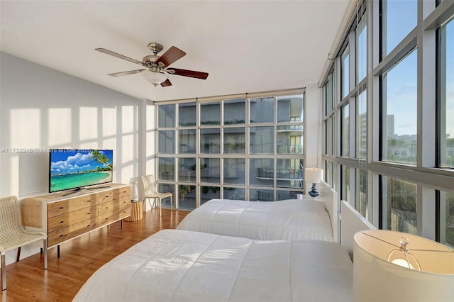 bedroom with hardwood / wood-style floors, floor to ceiling windows, and ceiling fan