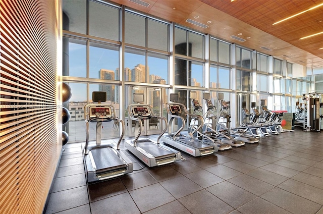 workout area featuring a wall of windows, wooden ceiling, and a high ceiling