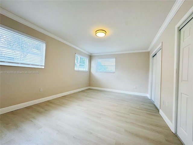 unfurnished bedroom featuring ornamental molding, light hardwood / wood-style floors, and multiple windows