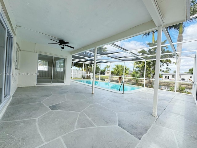 view of swimming pool featuring ceiling fan, a lanai, and a patio area