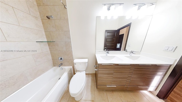 full bathroom featuring tiled shower / bath, vanity, and toilet