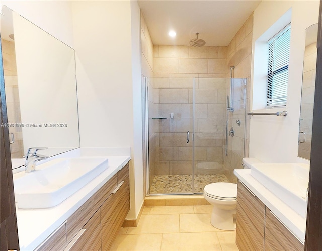 bathroom featuring vanity, toilet, tile patterned floors, and walk in shower