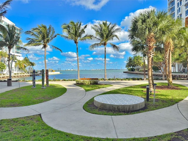 view of property's community featuring a lawn and a water view