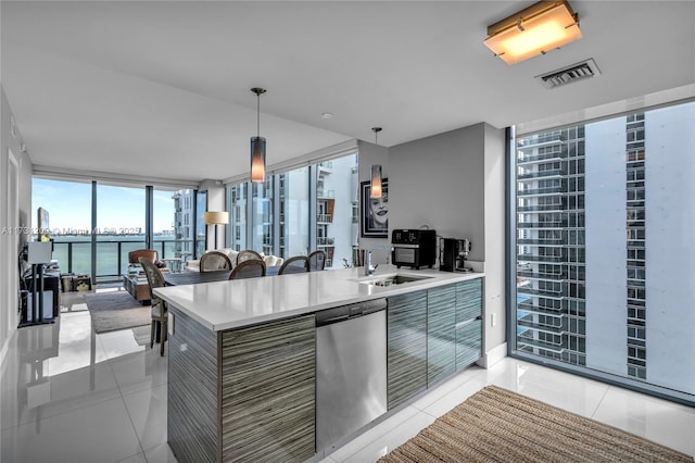 kitchen with dishwasher, a wall of windows, hanging light fixtures, light tile patterned floors, and a water view