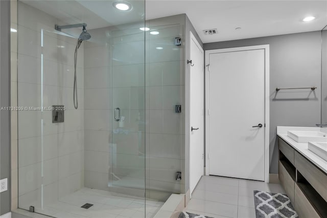 bathroom featuring tile patterned flooring, vanity, and a shower with shower door