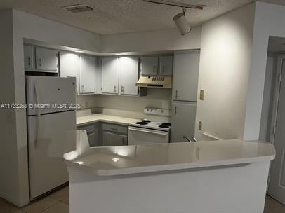 3360 N Pinewalk Dr N Unit 1315, Margate, FL 33063 - kitchen featuring range hood, white range with electric stovetop, freestanding refrigerator, a peninsula, and a textured ceiling