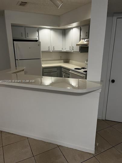 3360 N Pinewalk Dr N Unit 1315, Margate, FL 33063 - kitchen featuring white appliances, under cabinet range hood, tile patterned floors, and light countertops