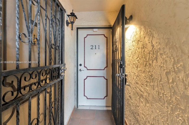 entryway with dark tile patterned floors