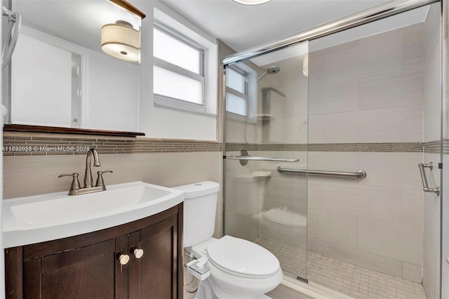 bathroom featuring a shower with door, vanity, tile walls, and decorative backsplash