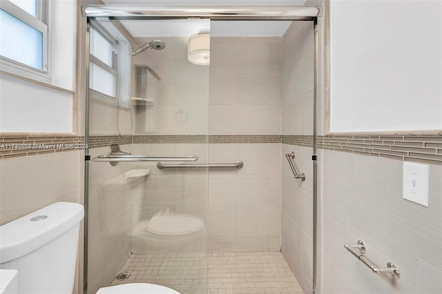 bathroom featuring tile walls, an enclosed shower, and toilet