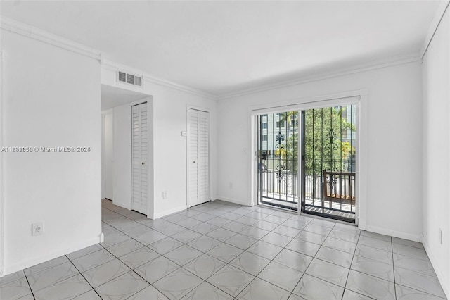 unfurnished room featuring ornamental molding and light tile patterned flooring