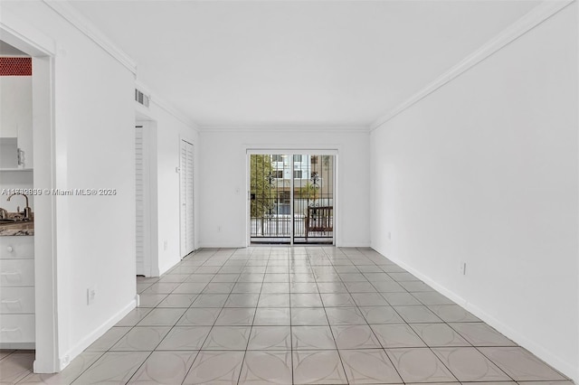 tiled spare room featuring sink and crown molding