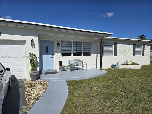 entrance to property with a porch, a garage, and a yard