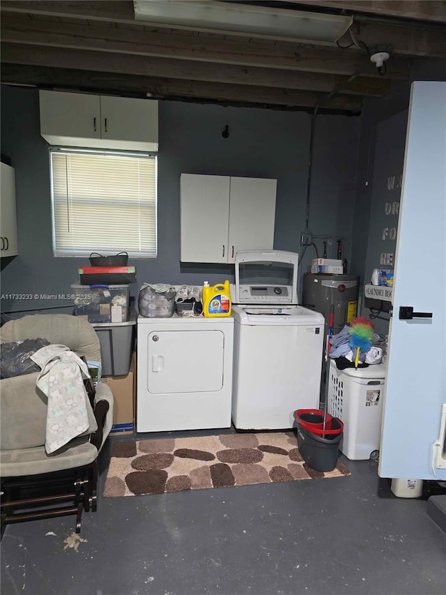 washroom featuring electric water heater, washer and clothes dryer, and cabinets