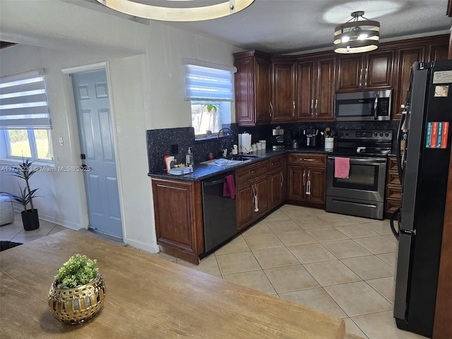 kitchen featuring sink, backsplash, dark brown cabinetry, black appliances, and light tile patterned flooring