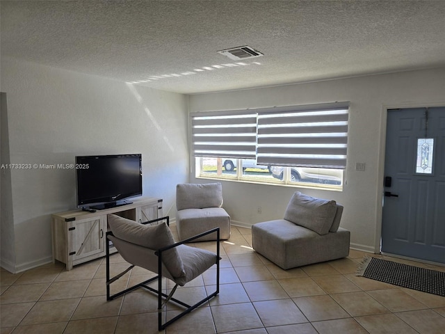 tiled living room featuring a textured ceiling