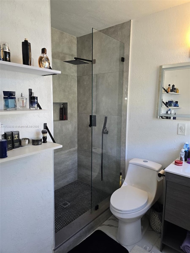 bathroom with vanity, toilet, and a tile shower