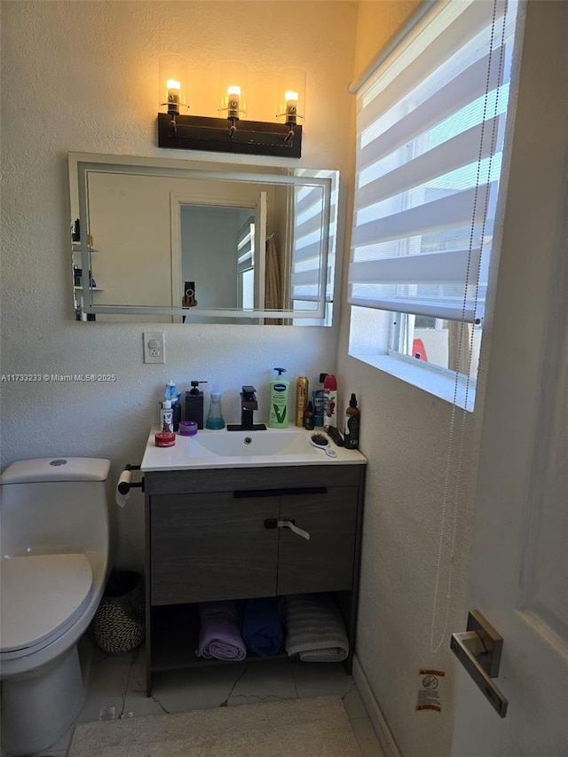 bathroom with tile patterned flooring, vanity, and toilet